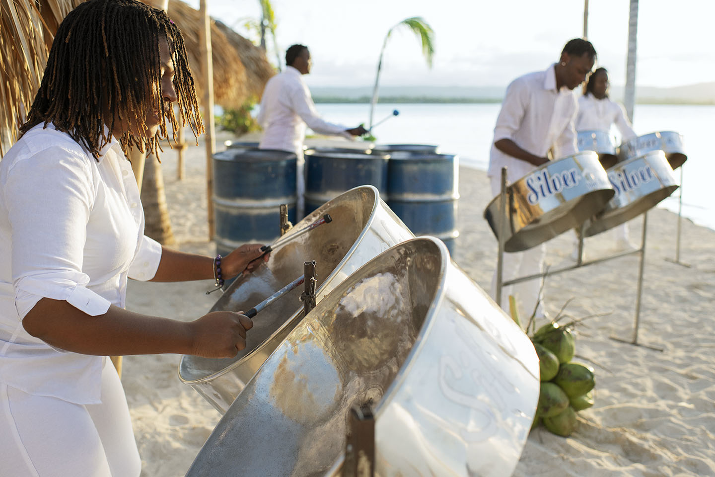 Woman playing steelpan drums on a beach in Jamaica Woman playing steelpan drums on a beach in Jamaica