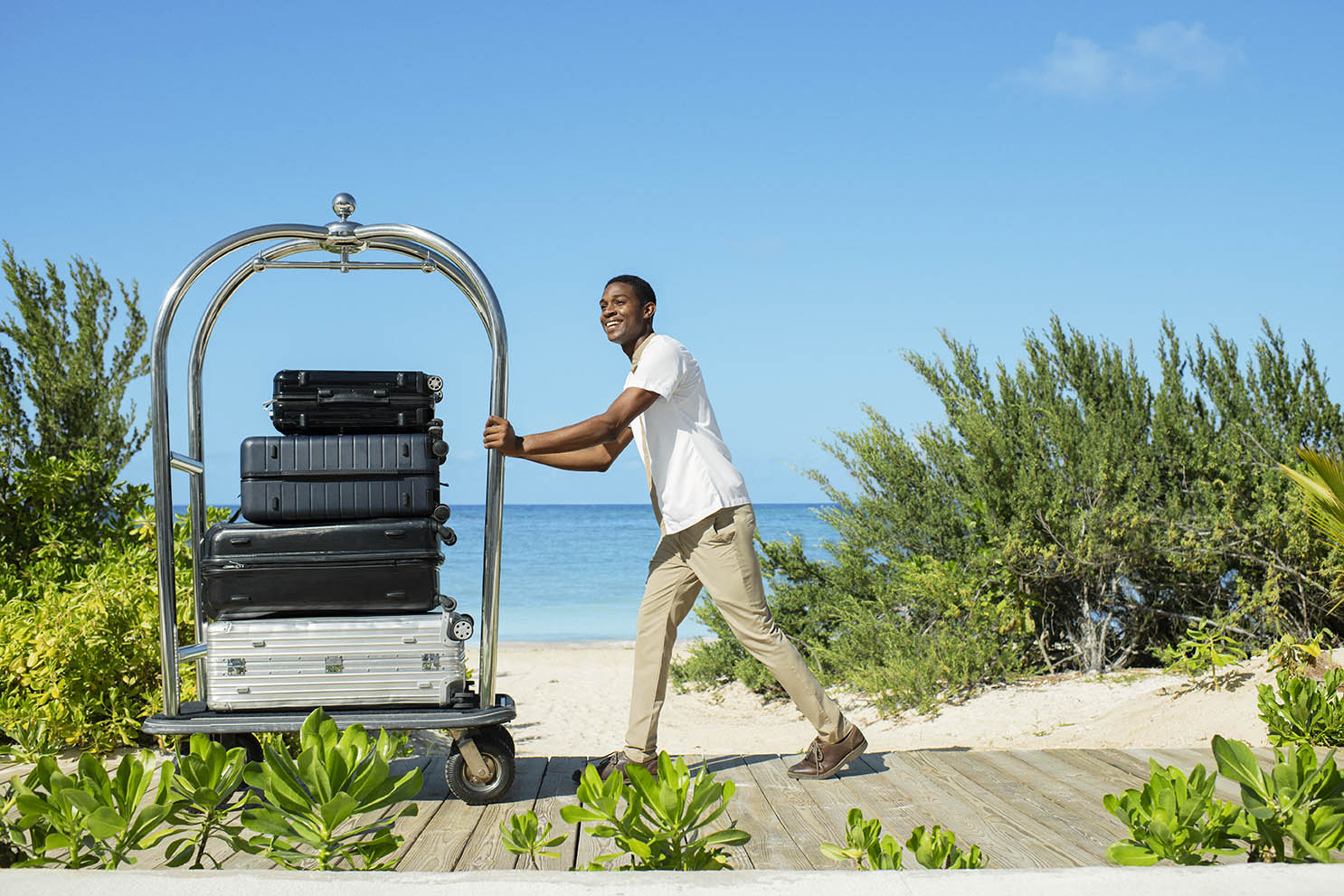 Bellboy helping guests with their luggage in Excellence Oyster Bay Bellboy helping guests with their luggage in Excellence Oyster Bay